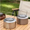 Two 1L pure titanium kettles in crystal and matte finishes on an outdoor table.