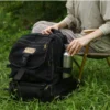Single-wall titanium water bottle stored in the side pocket of a backpack outdoors.