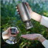 Single-wall titanium water bottle being poured with a close-up inset of the cap and thread detail.