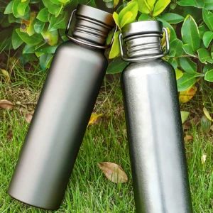 Two single-wall titanium water bottles shown on grass in matte and crystal silver finishes.