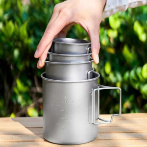TA1 titanium folding handle mugs in nested sizes being placed into the largest mug for compact storage.