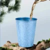 Blue TiRoam pure titanium cup with tea pouring outdoors, lightweight titanium cup for camping and travel