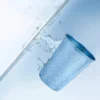 Blue TiRoam titanium cup with clean water splash, lightweight pure titanium cup for refreshing drinks