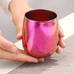 Colorful double-wall pure titanium tumbler held in hand showing its compact shape