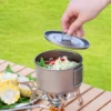 TiRoam titanium camping pot with lid being lifted over hot noodles, outdoor cooking pot for camping, backpacking, and simple trail meals.