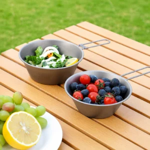 TiRoam titanium folding bowls serving fruit and salad on an outdoor camping table, lightweight reusable bowls for picnics, backpacking, and outdoor meals.