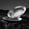 Two TiRoam pure titanium plates displayed on dark rock texture, durable lightweight titanium dinnerware for outdoor dining, camping, and minimalist tableware.