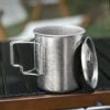 Pure titanium camp mug with lid on a camp table