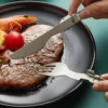 Pure titanium folding knife and fork cutting steak