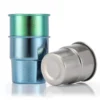 Studio product shot of TiRoam stackable titanium camping cups, featuring a green cup stacked on a blue cup and a silver cup lying on its side.