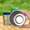 Close-up of a hand holding a silver TiRoam titanium cup, showcasing the premium crystalline texture on the inside bottom.
