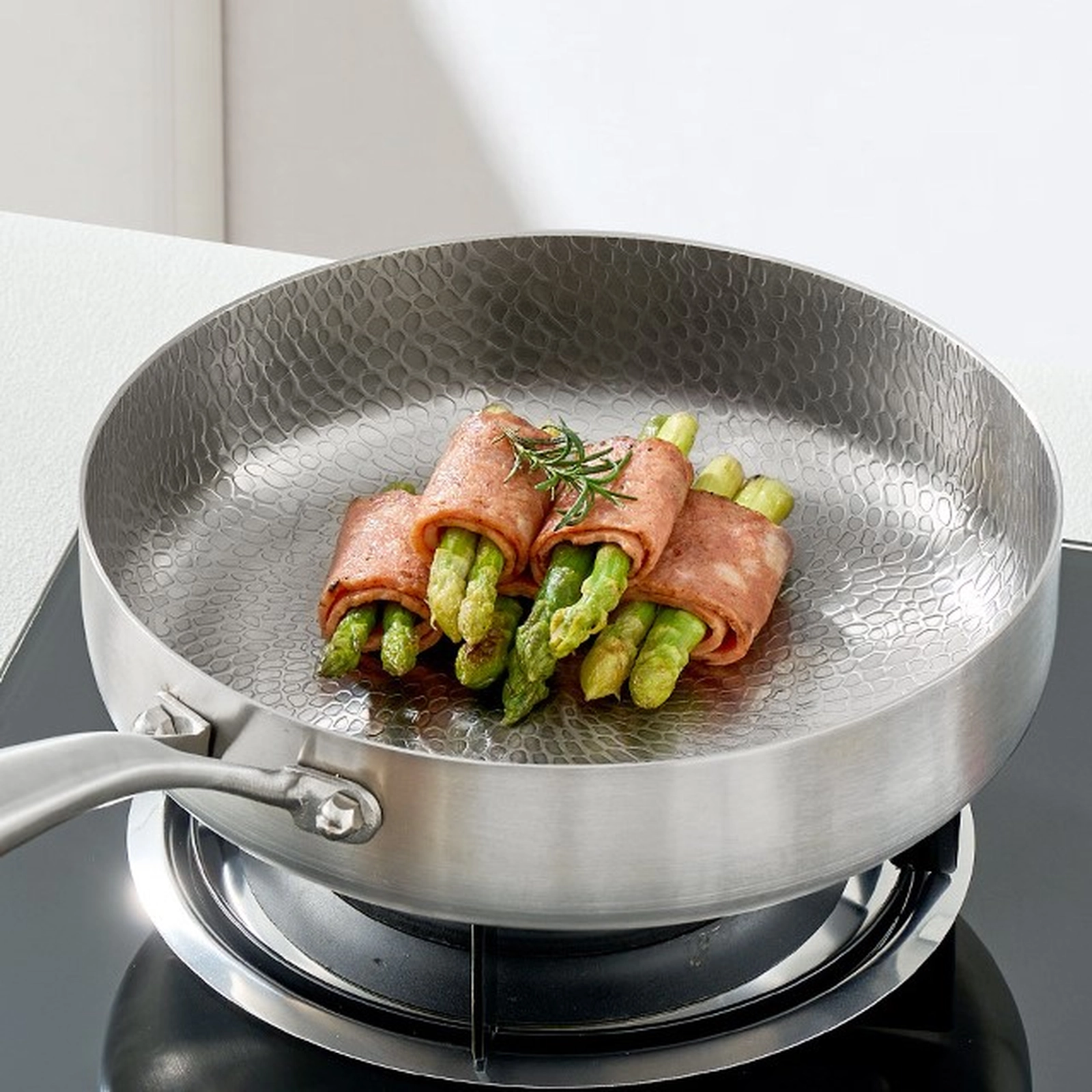 Titanium frying pan cooking bacon-wrapped asparagus