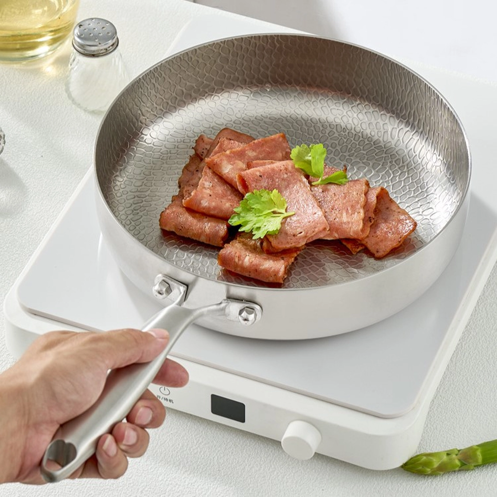 Titanium frying pan searing meat on an induction cooktop