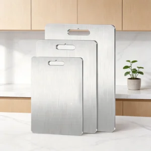 Three sizes of flat pure titanium cutting boards displayed upright in a bright modern kitchen.