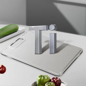 Grooved pure titanium cutting board displayed with a titanium symbol and fresh vegetables.
