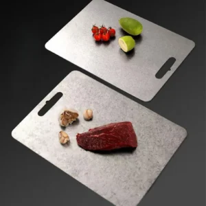 Pure titanium cutting boards shown with fruit, vegetables, garlic, and fresh meat for everyday food prep.