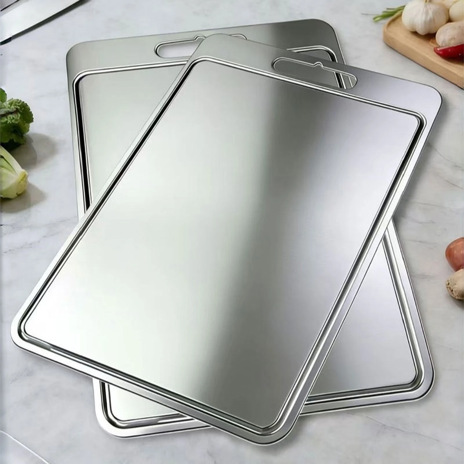 Three grooved pure titanium cutting boards in different sizes displayed together on a kitchen counter.