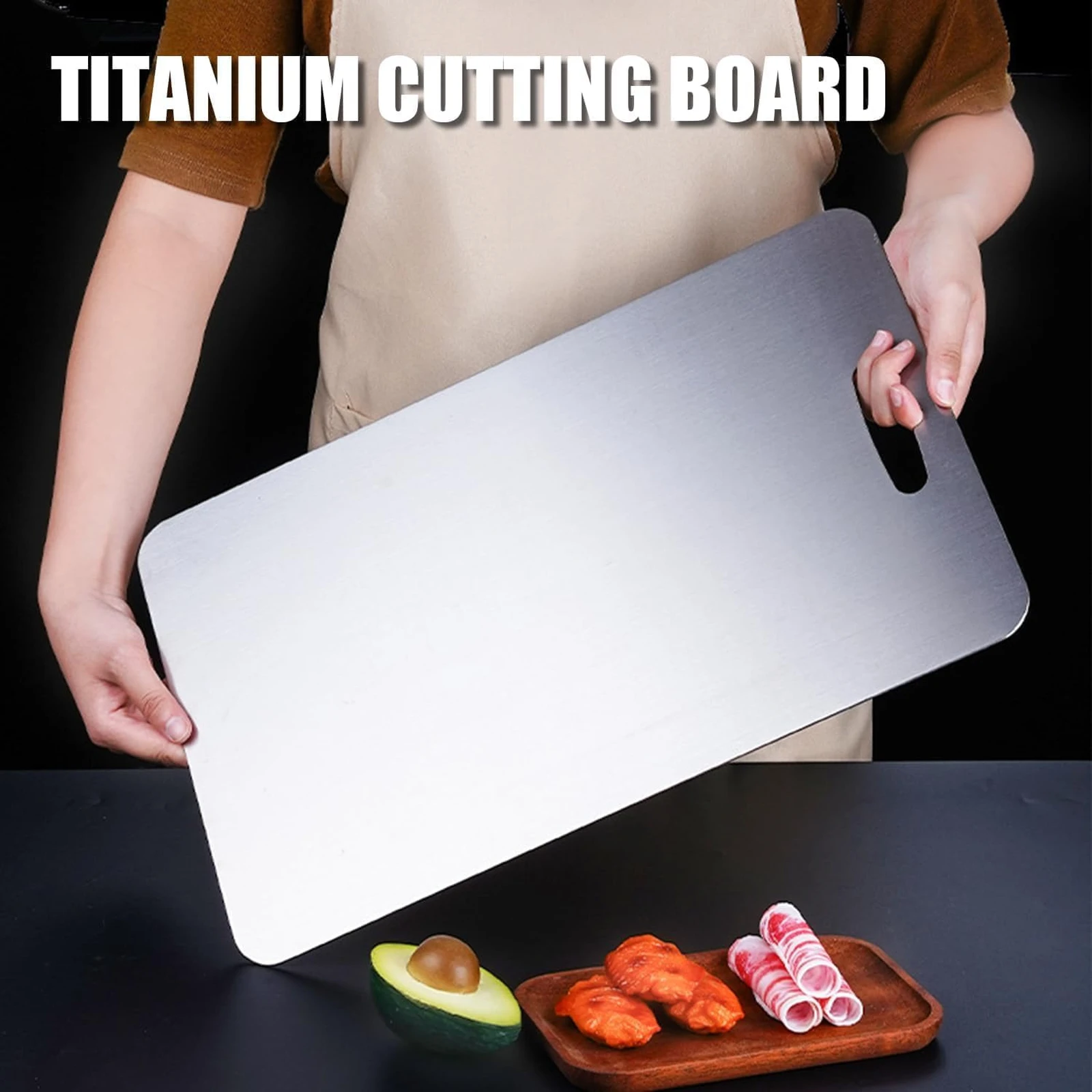 Person holding a large pure titanium cutting board with rounded corners and built-in handle.