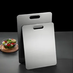 Two pure titanium cutting boards in different sizes displayed on a dark kitchen counter.