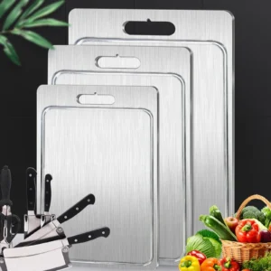 Small, medium, and large grooved pure titanium cutting boards shown together with kitchen tools and vegetables.
