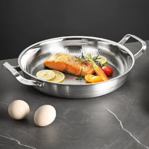 Titanium frying pan with hammered cooking surface used to cook salmon and vegetables
