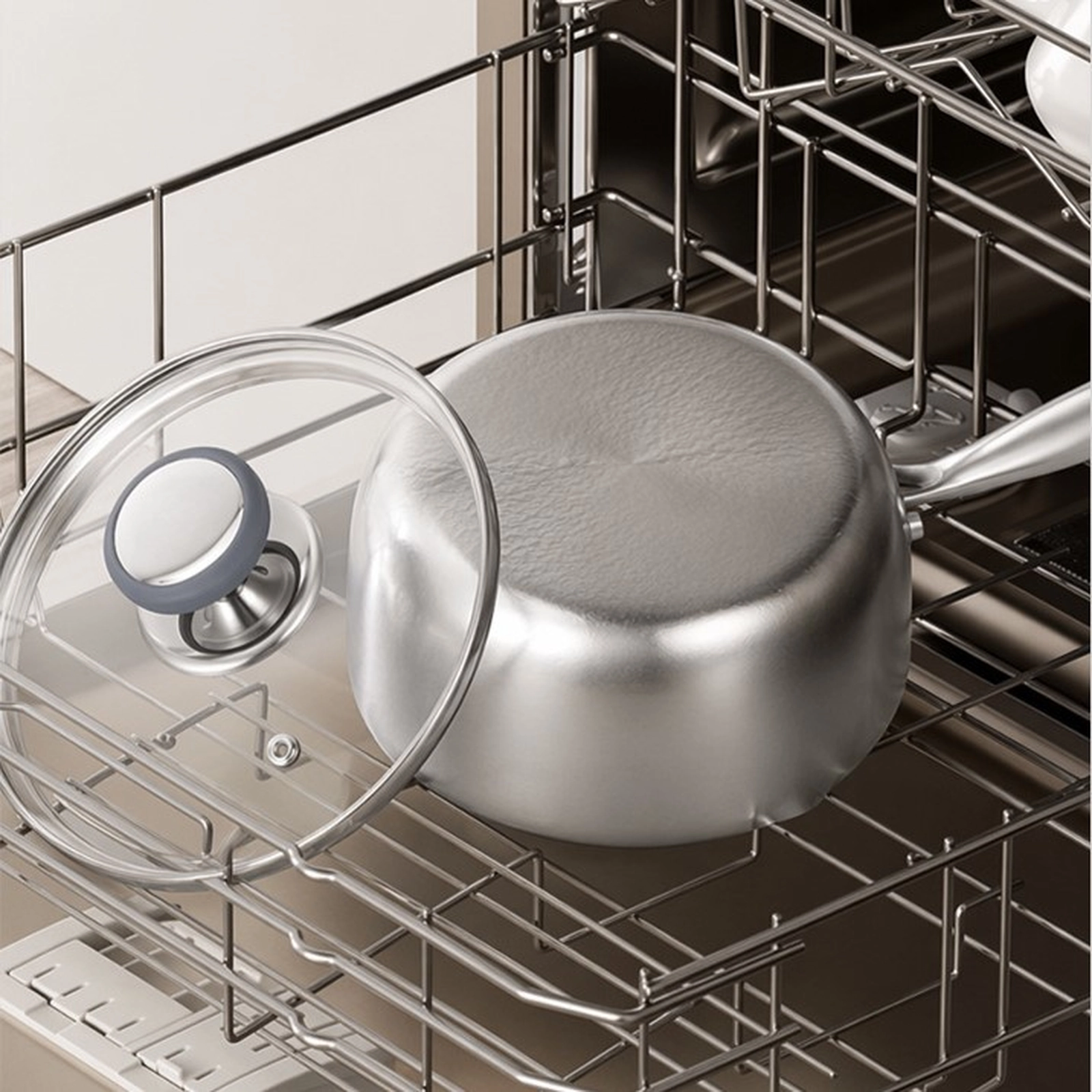 Titanium saucepan and glass lid placed in a dishwasher for cleaning
