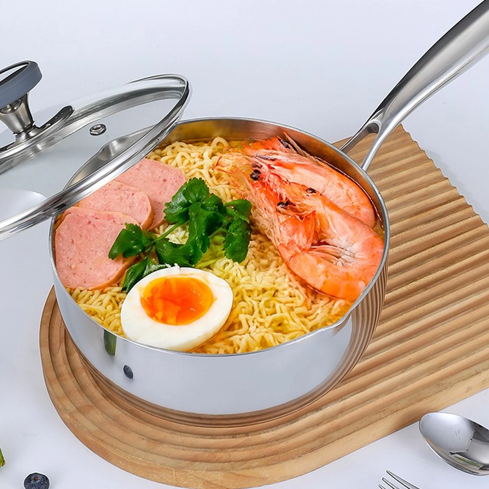 Titanium saucepan filled with noodles, shrimp, egg, and vegetables