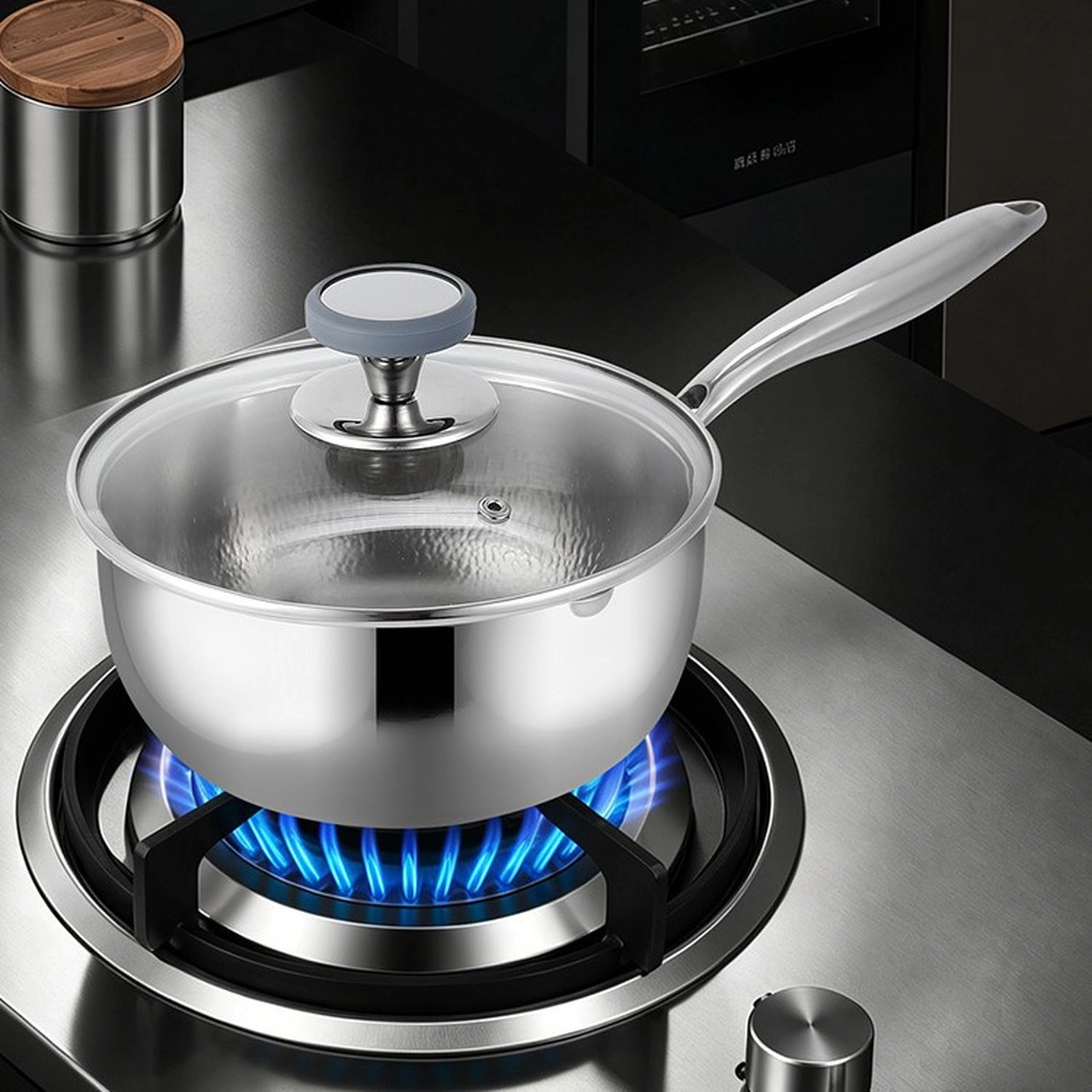 Pure titanium saucepan with glass lid cooking on a gas stovetop