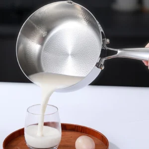Titanium saucepan with pouring spout used to pour milk