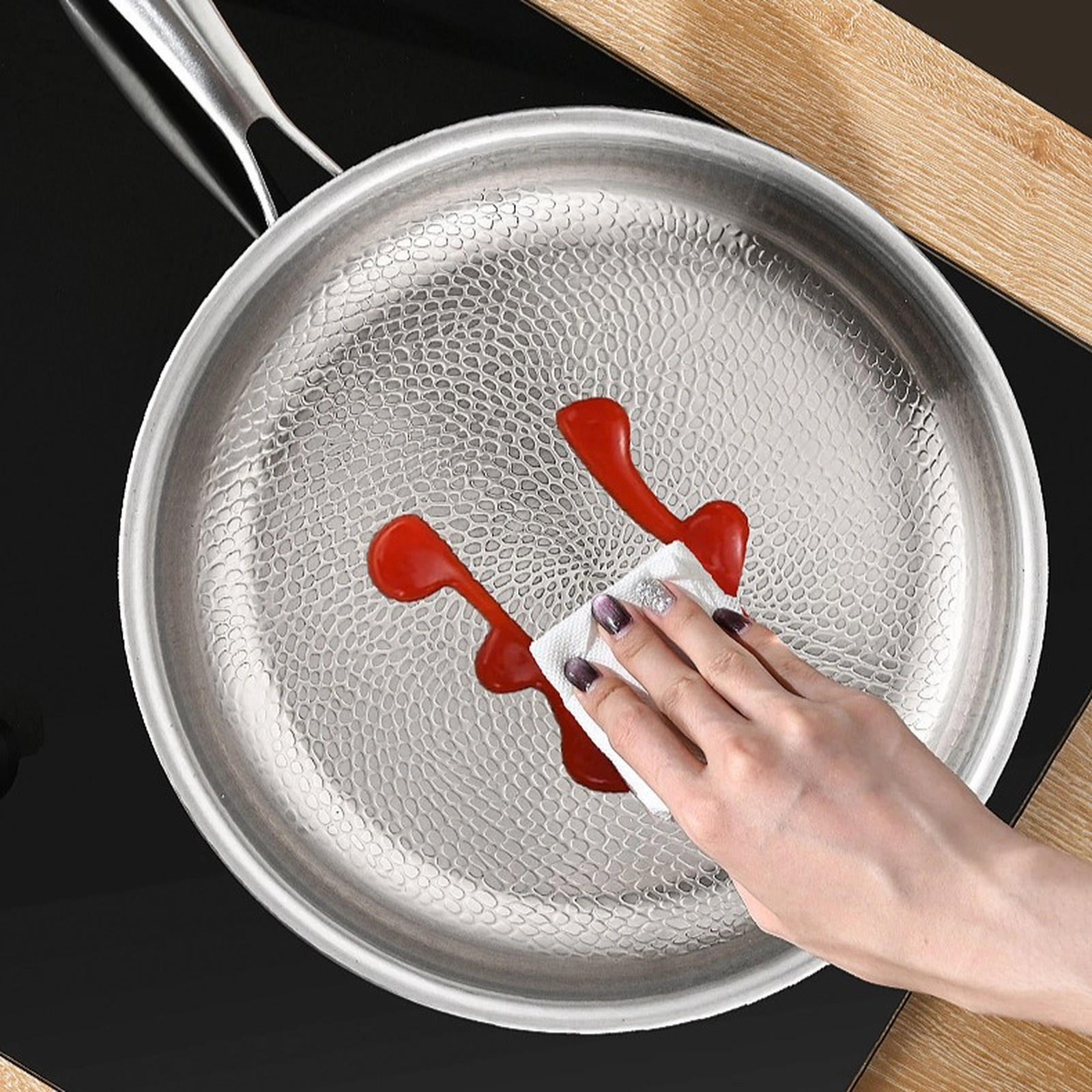 Titanium frying pan being wiped clean after cooking