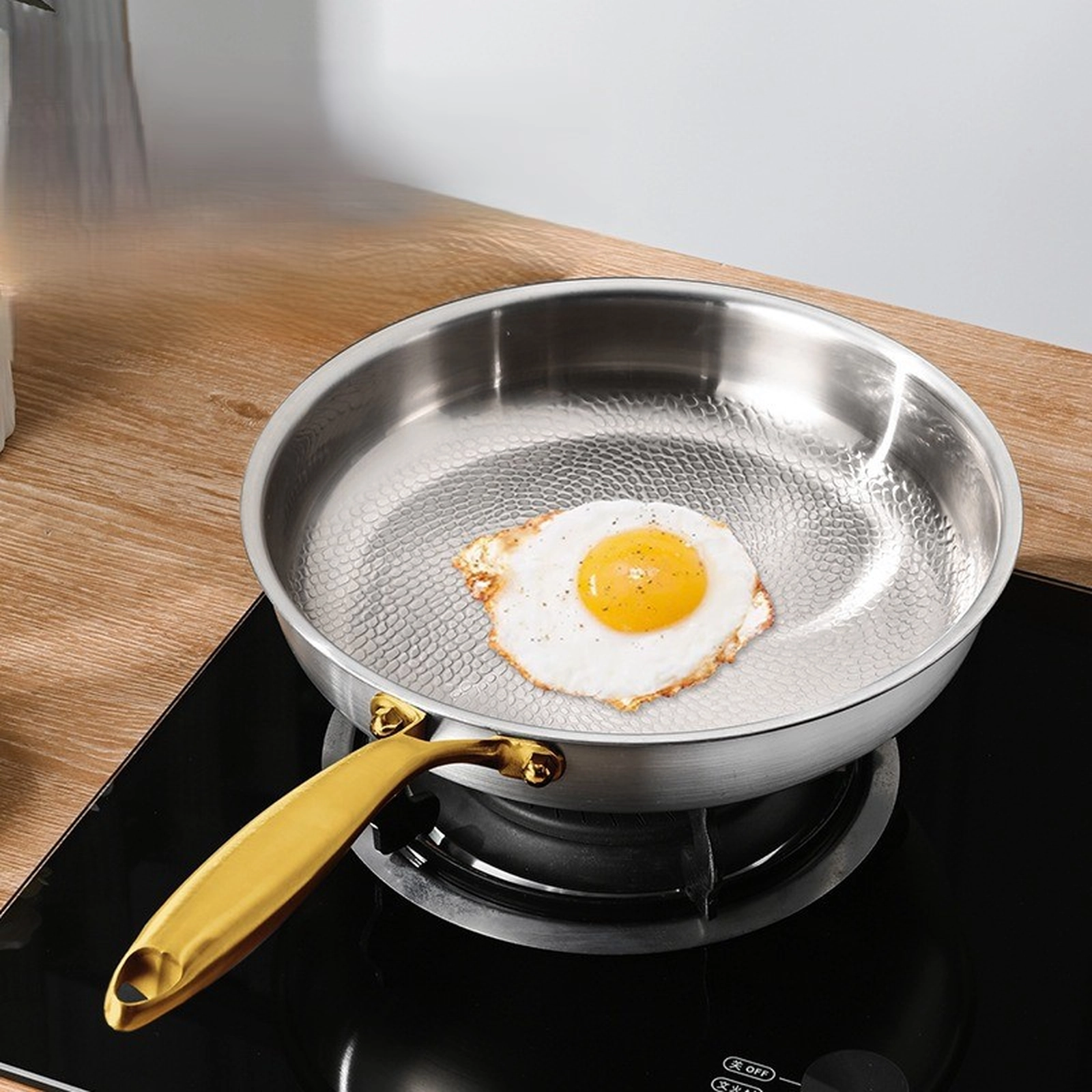 Fried egg cooking in a titanium frying pan with hammered surface