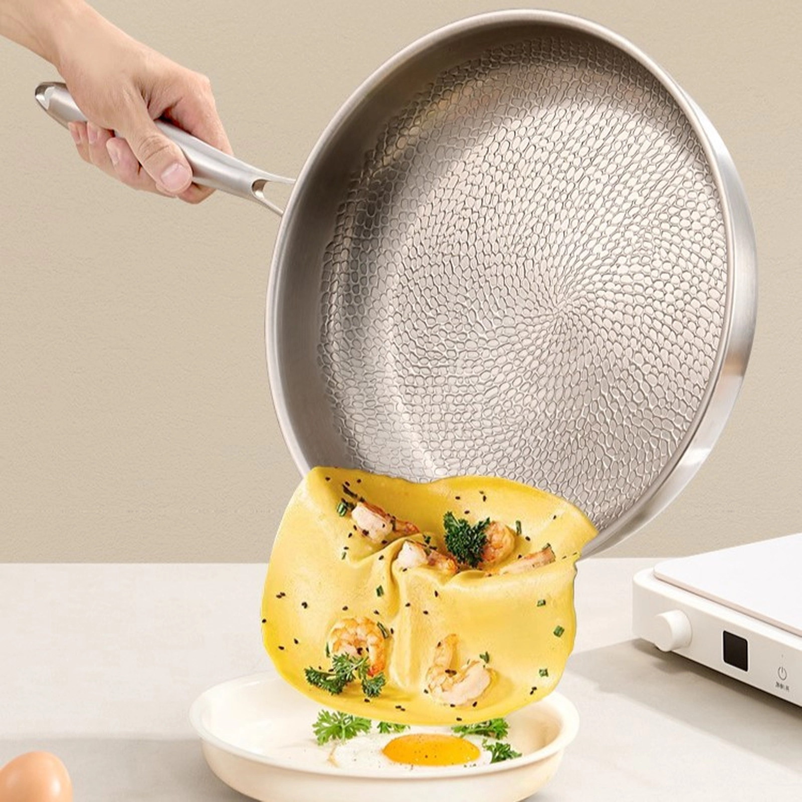 Omelet sliding from a titanium frying pan onto a plate