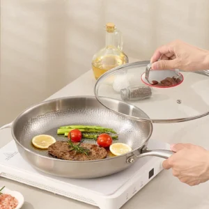 Titanium frying pan with glass lid cooking steak and vegetables