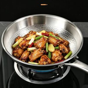 Chicken, ginger, and green onions cooking in a dragon-scale textured titanium frying pan.