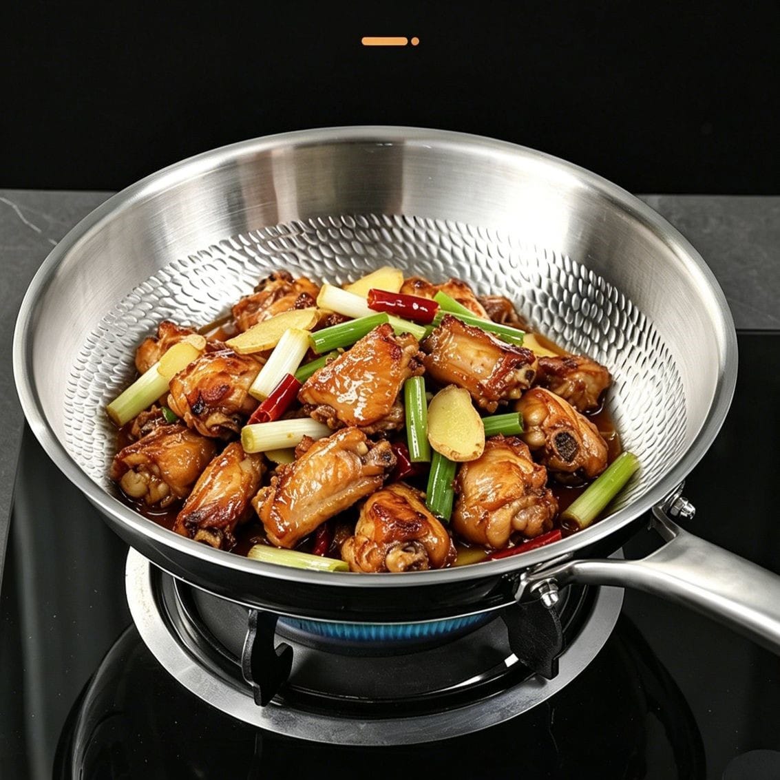Chicken, ginger, and green onions cooking in a dragon-scale textured titanium frying pan.