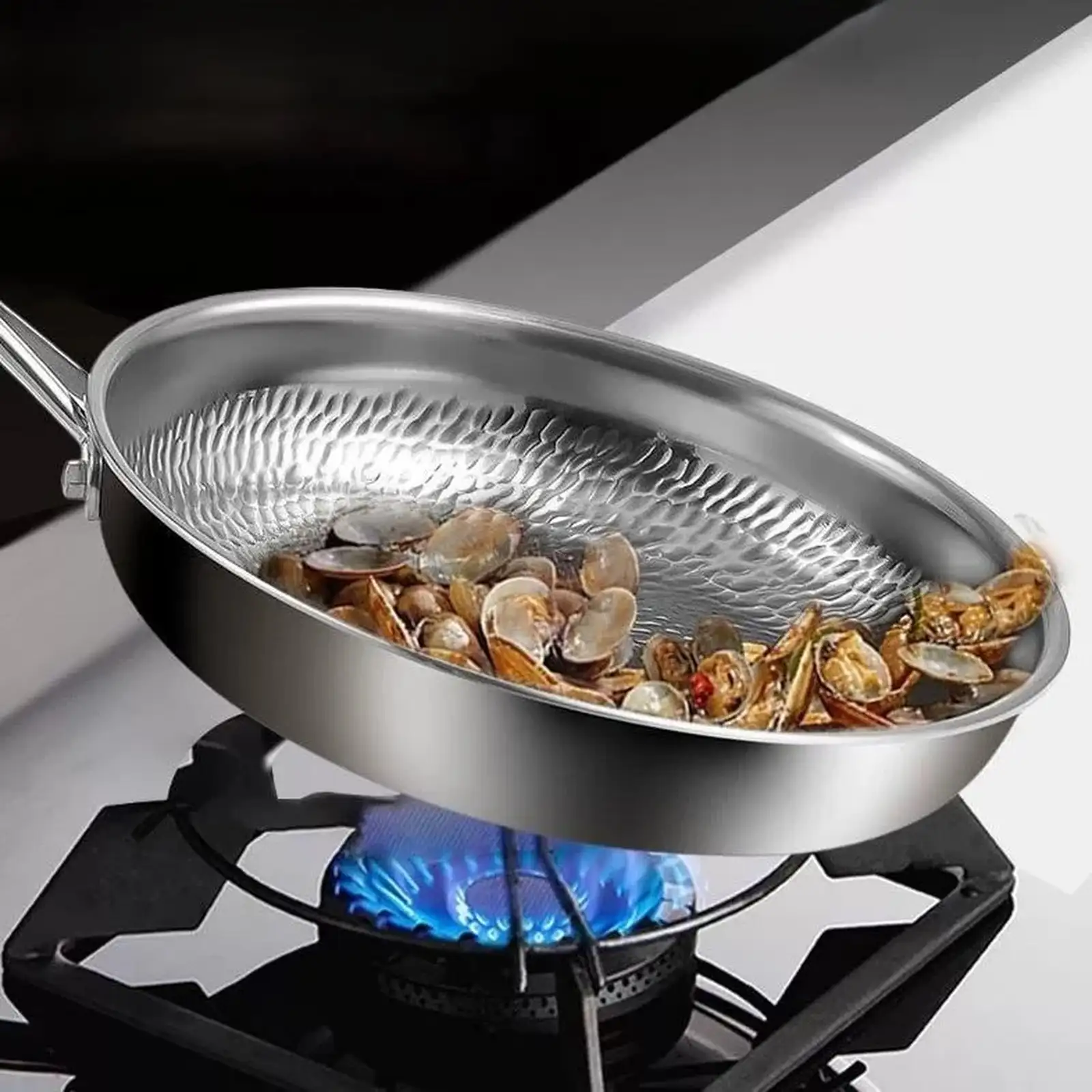 Titanium frying pan with a textured cooking surface positioned above a gas burner in a home kitchen.